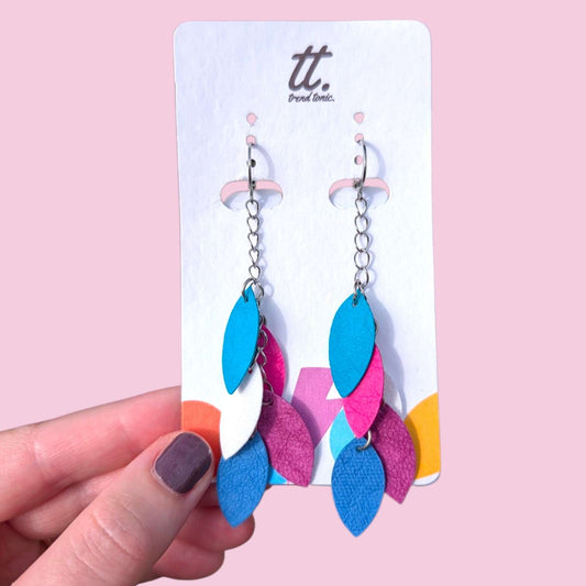 a hand holding a pair of earrings
