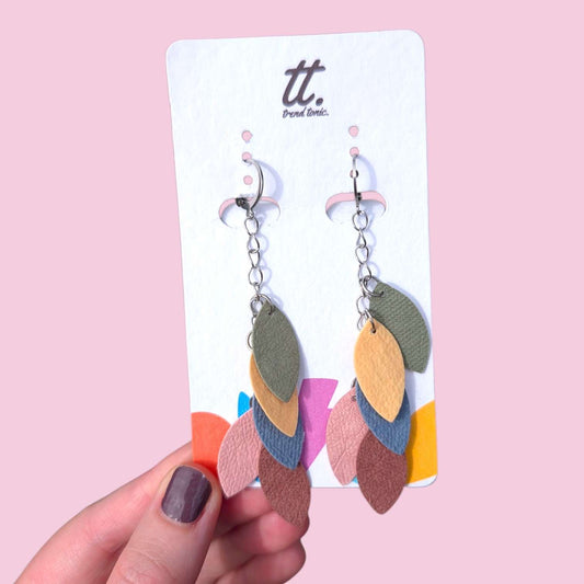 a hand holding a pair of earrings