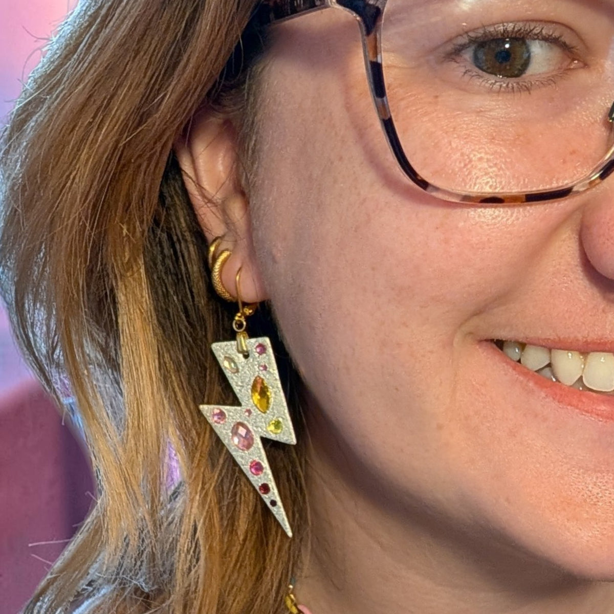 a woman wearing glasses and earrings