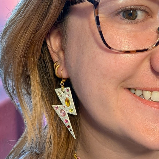 a woman wearing glasses and earrings