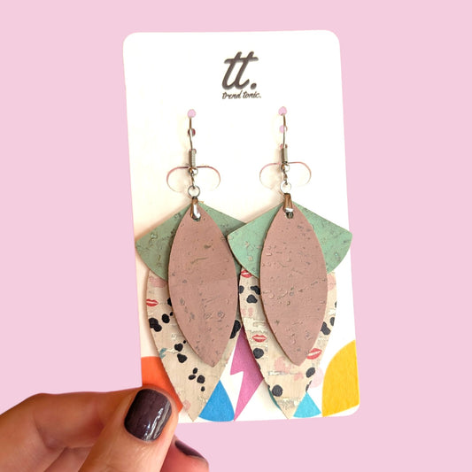 a hand holding a pair of earrings