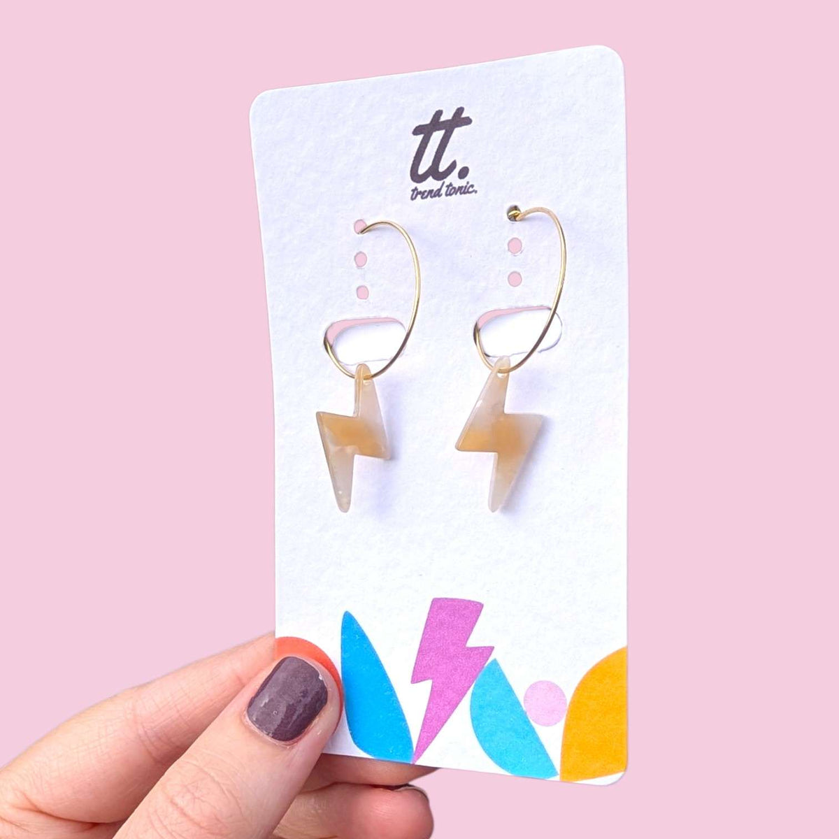 a hand holding a pair of earrings