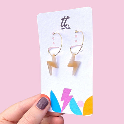 a hand holding a pair of earrings