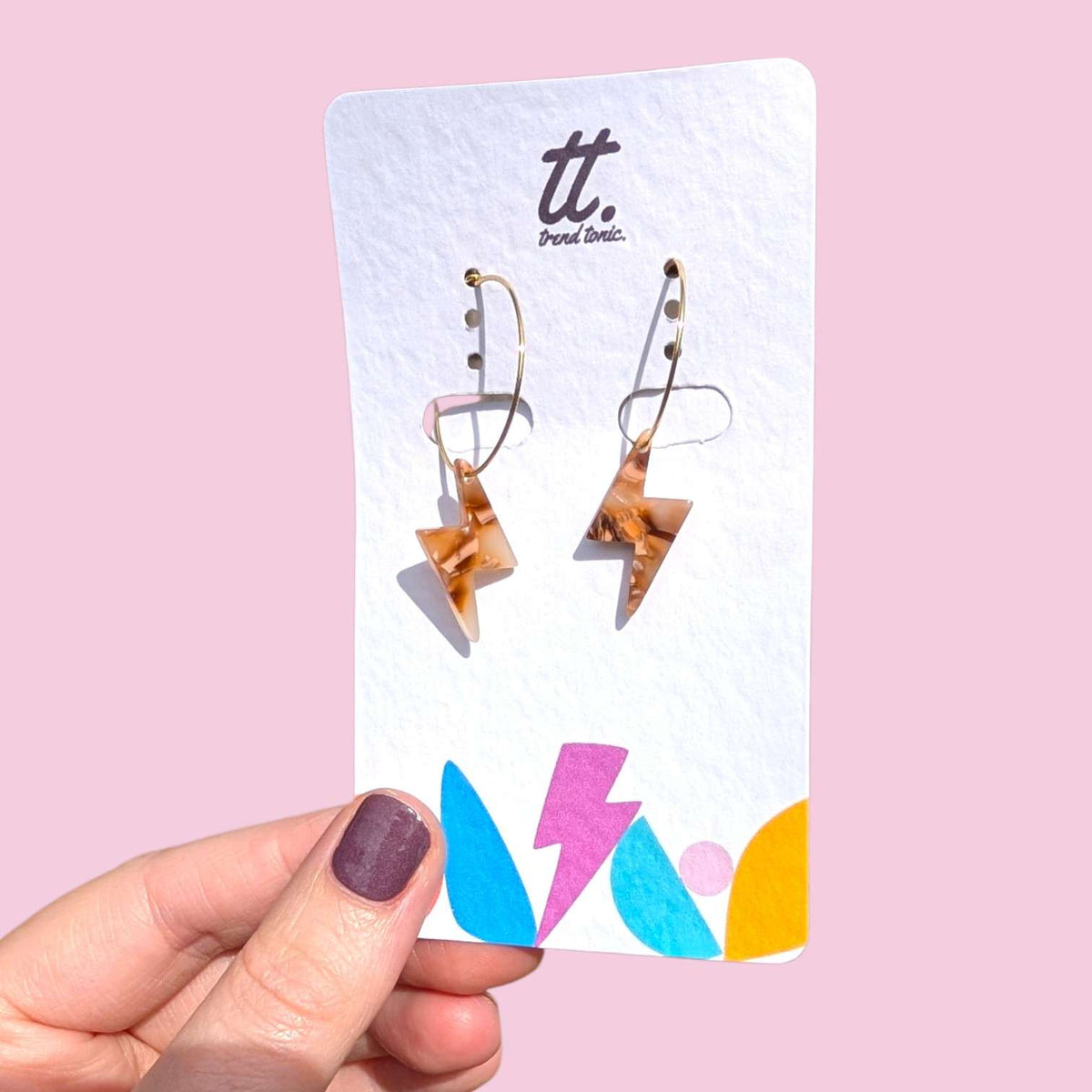 a hand holding a card with earrings