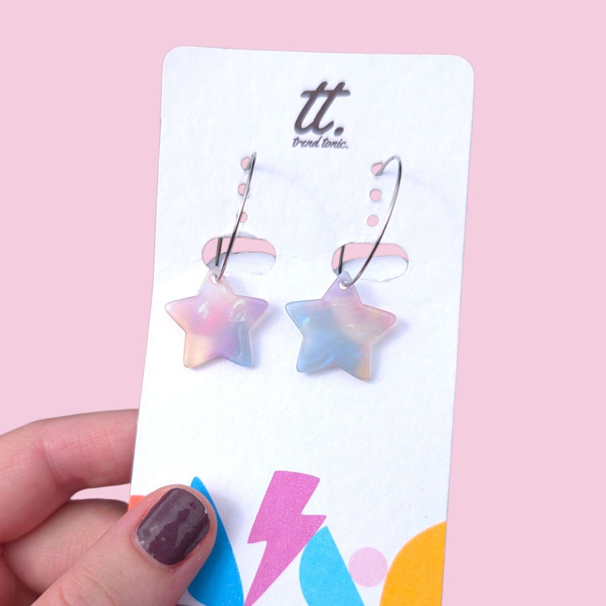 a hand holding a pair of earrings