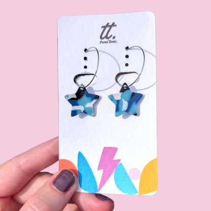 a hand holding a pair of earrings