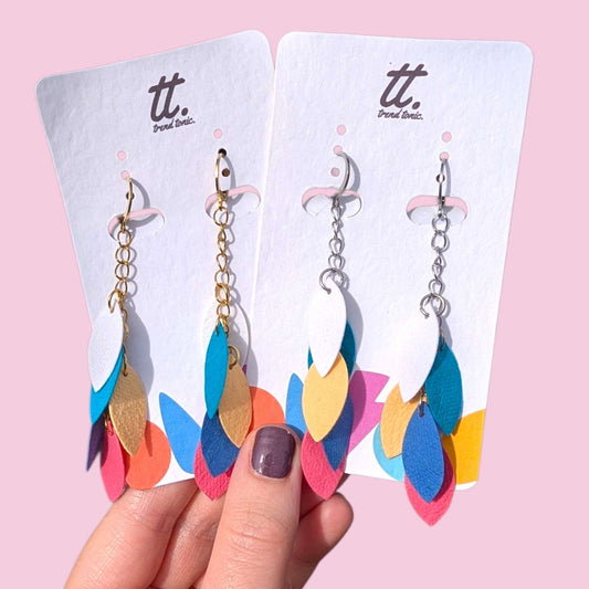 a hand holding a pair of earrings