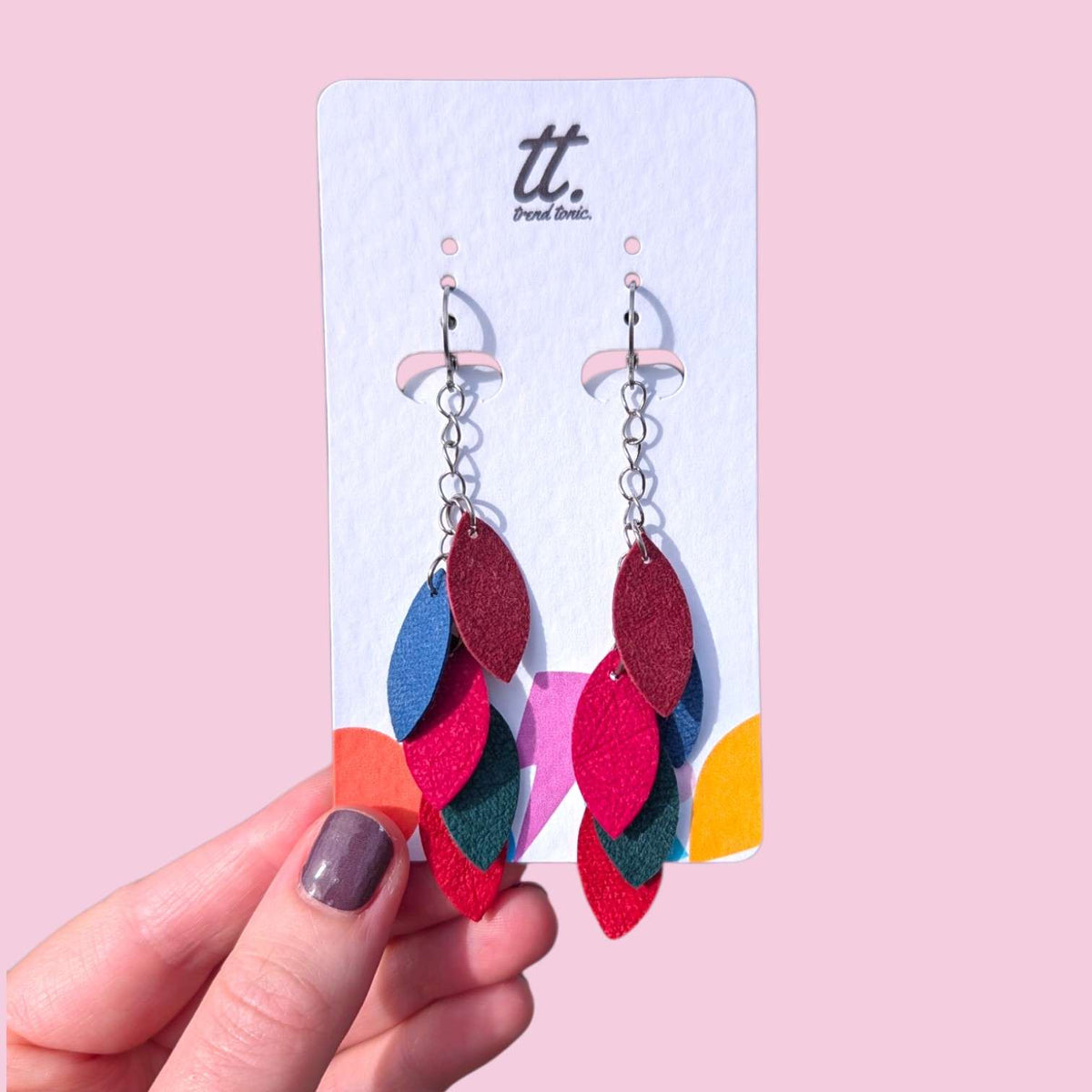 a hand holding a pair of earrings