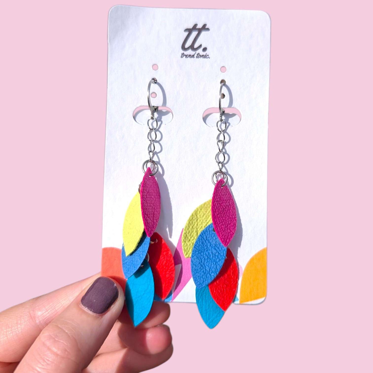 a hand holding a pair of earrings
