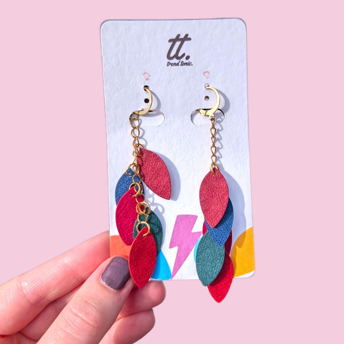 a hand holding a pair of earrings