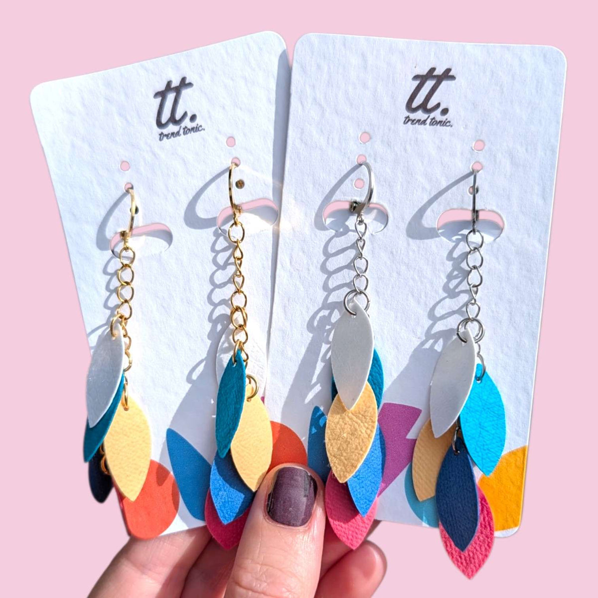 a hand holding a pair of earrings