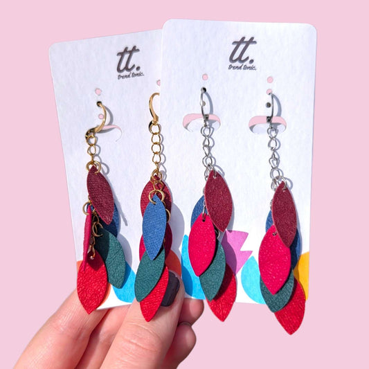 a hand holding a pair of earrings