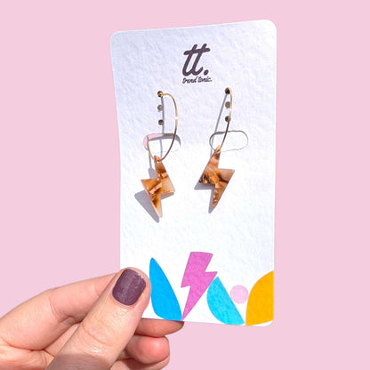 a hand holding a card with earrings