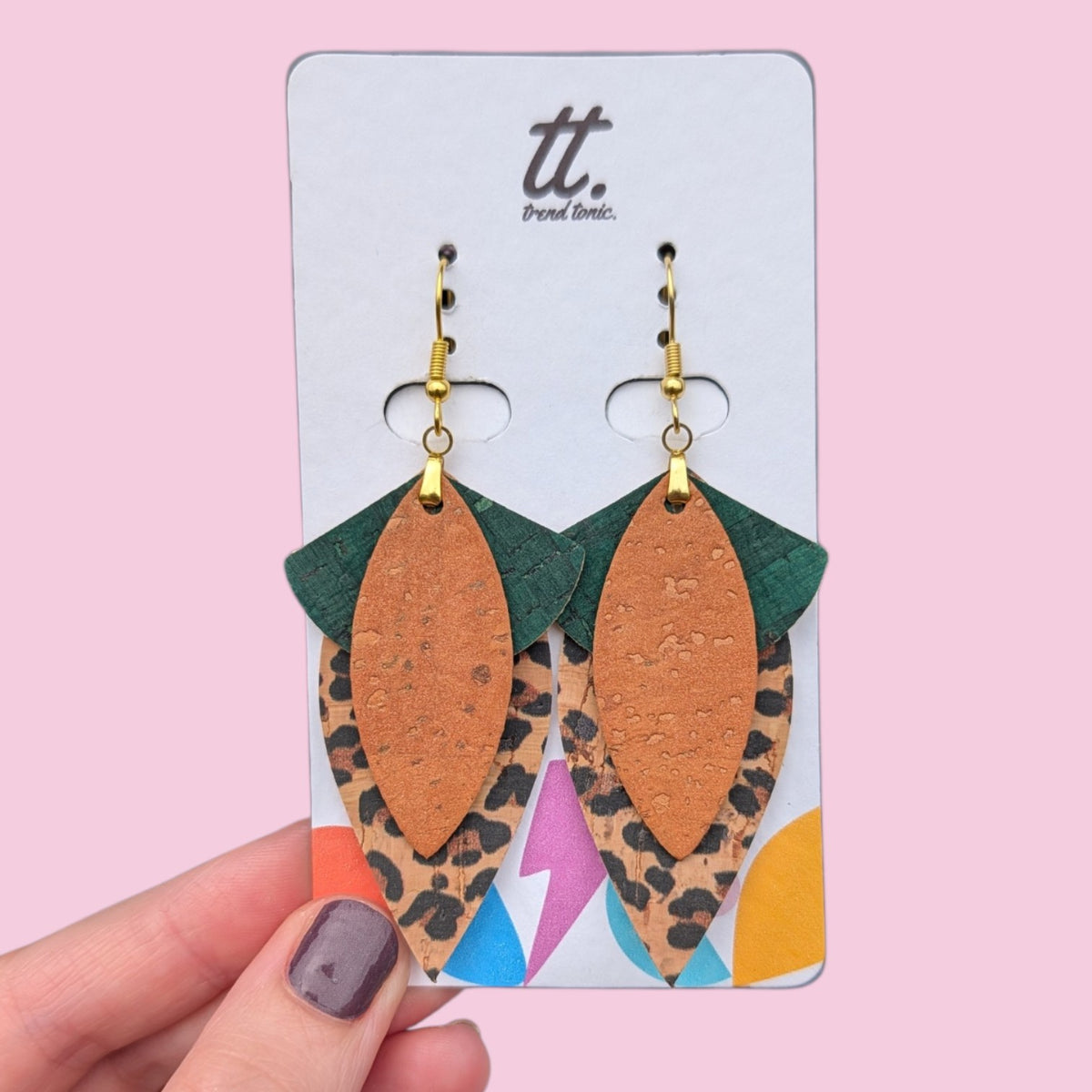 a hand holding a pair of earrings