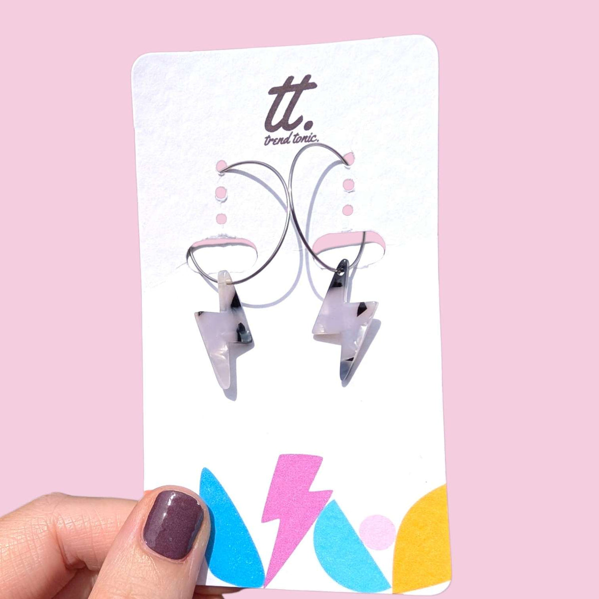a hand holding a card with earrings