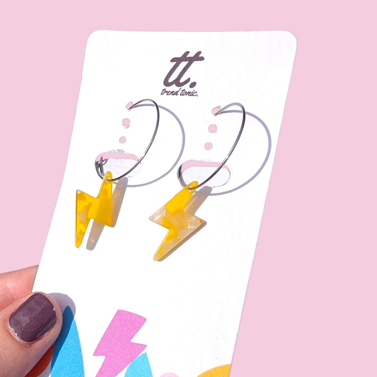 a hand holding a pair of earrings