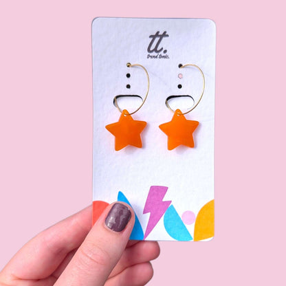 a hand holding a card with earrings