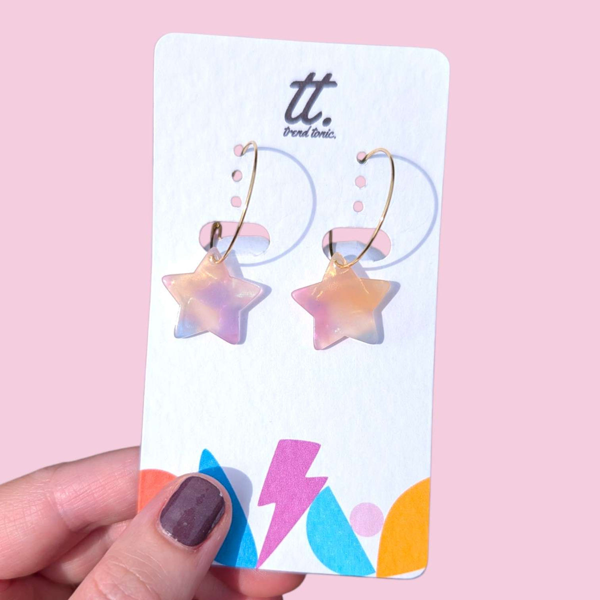 a hand holding a pair of earrings