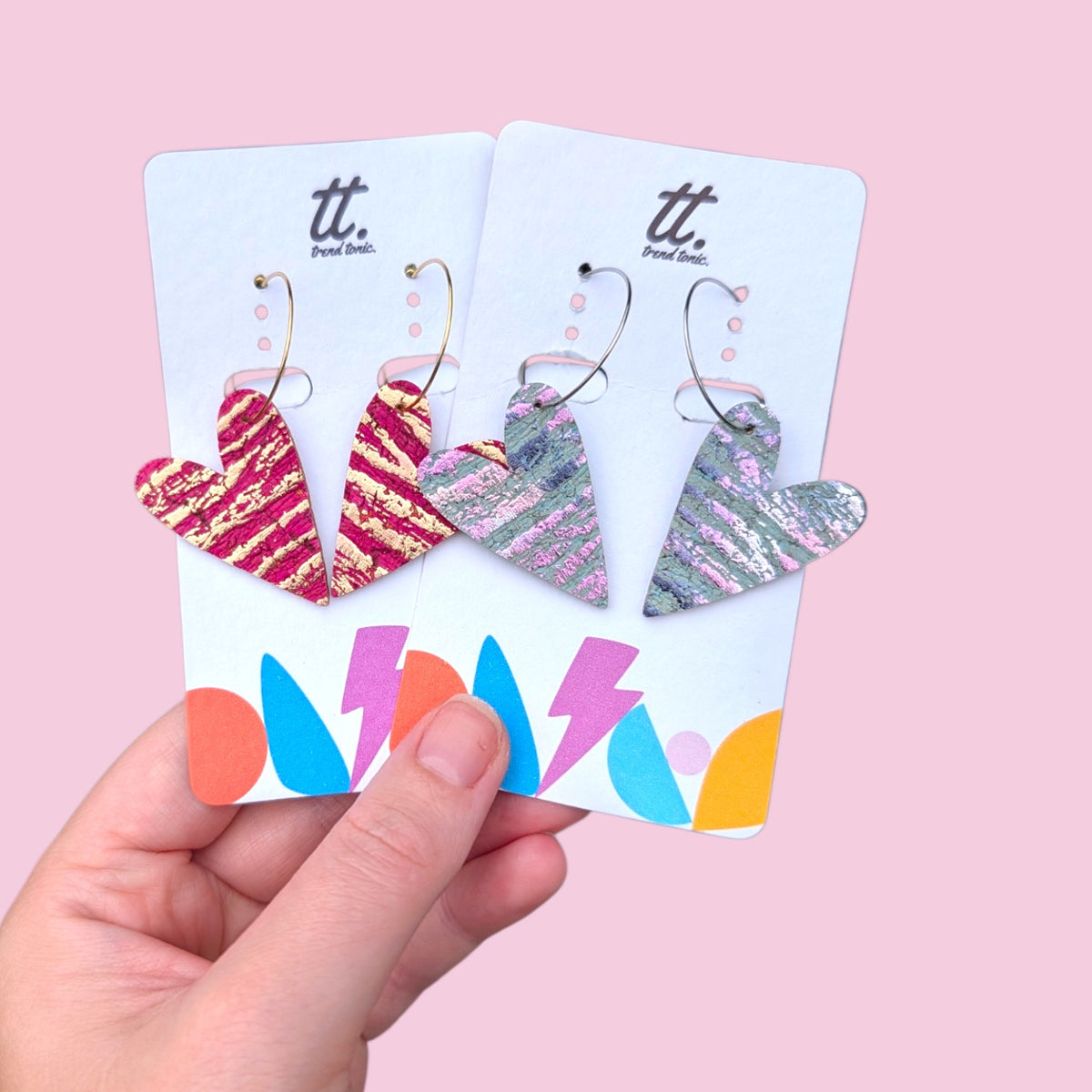 a hand holding a pair of earrings