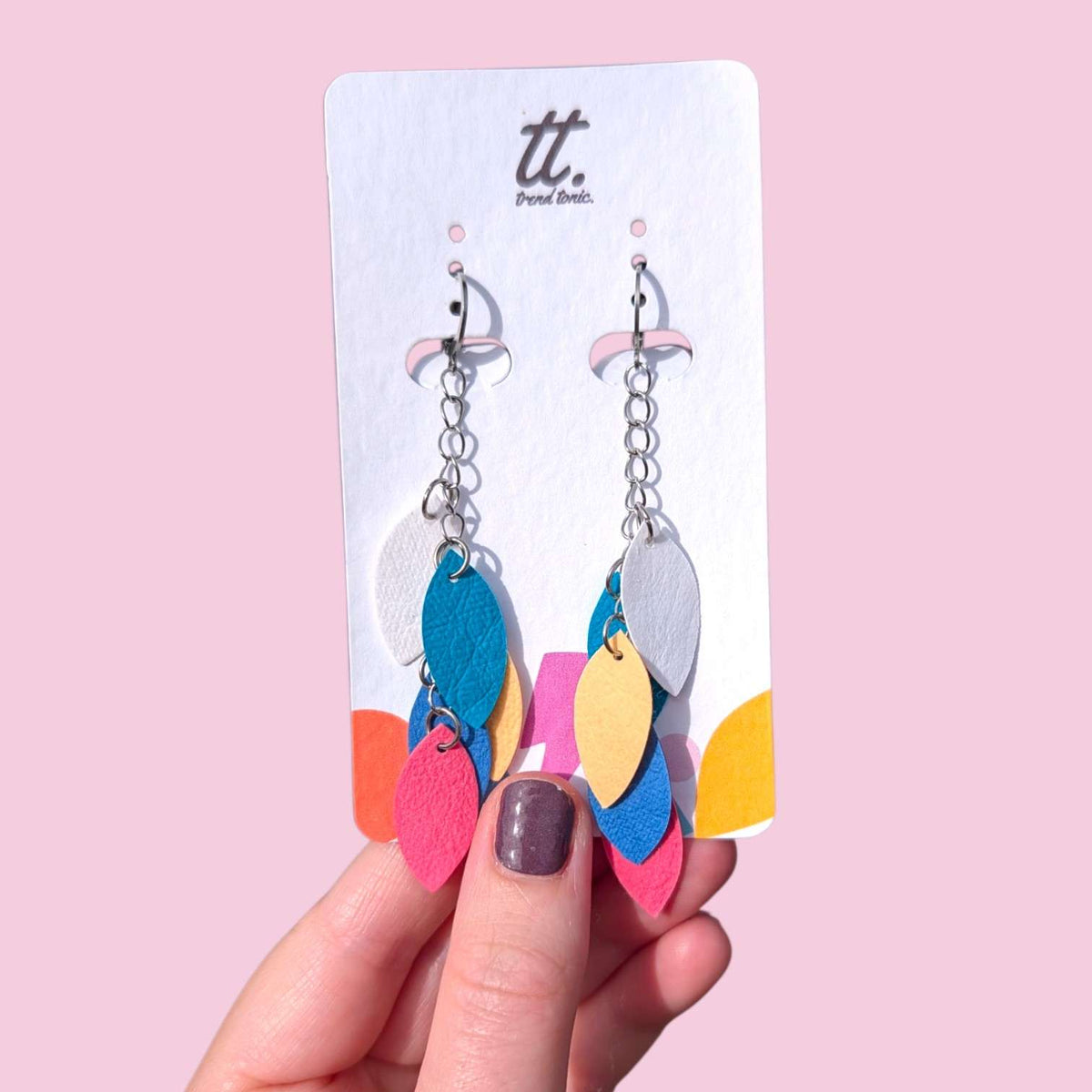 a hand holding a pair of earrings