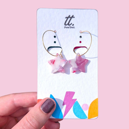 a hand holding a card with earrings