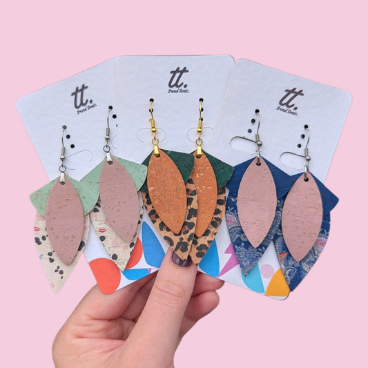 a hand holding a group of earrings