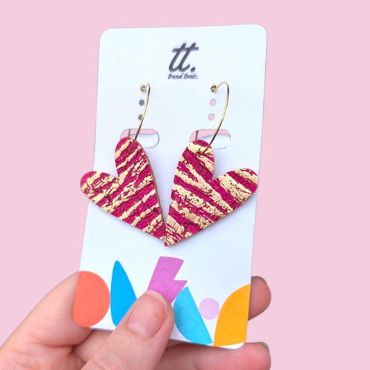 a hand holding a pair of earrings