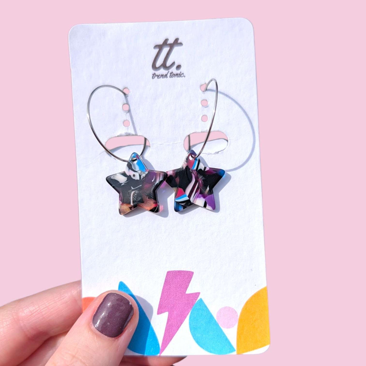 a hand holding a card with earrings