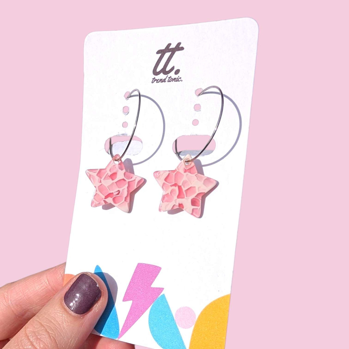 a hand holding a pair of earrings