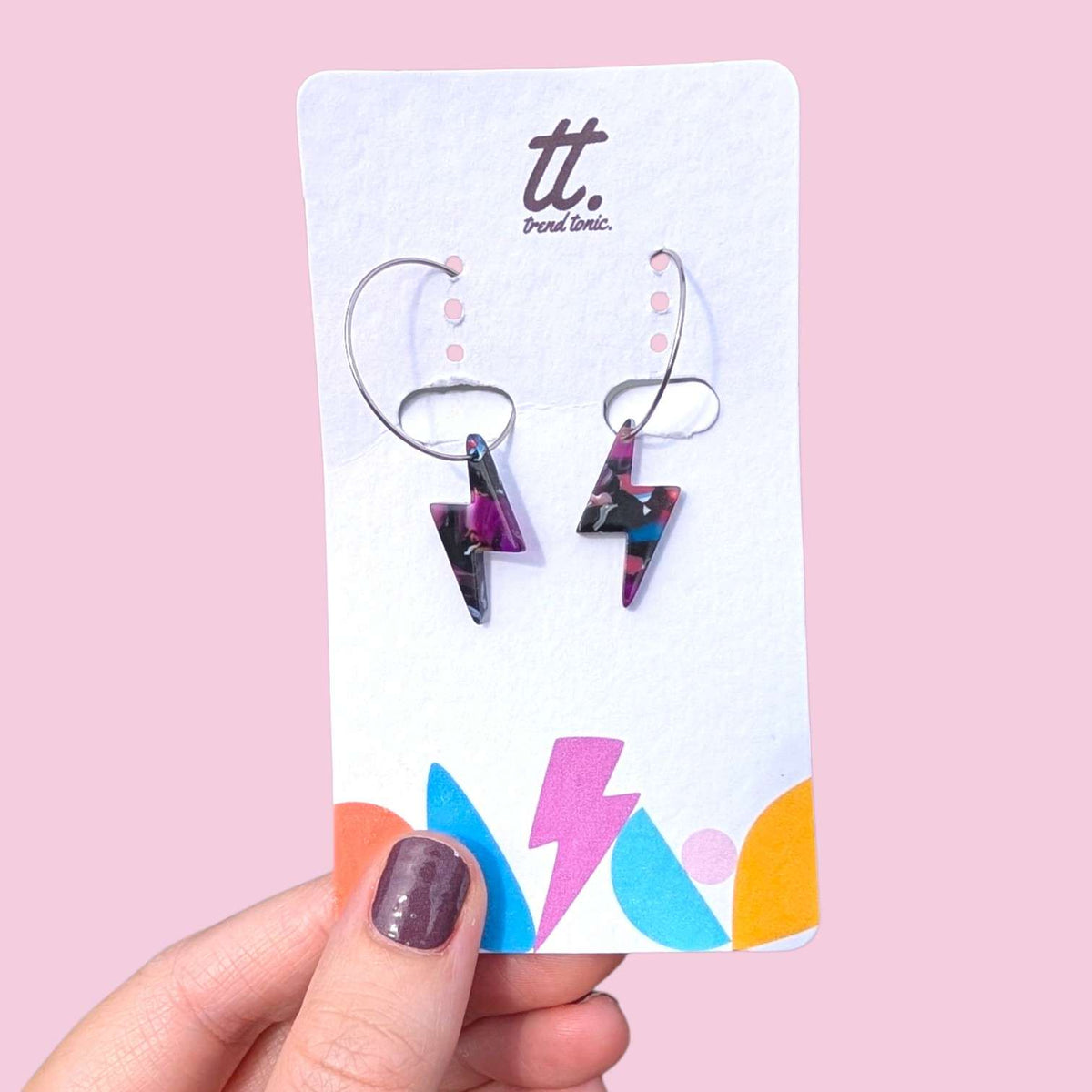 a hand holding a card with earrings