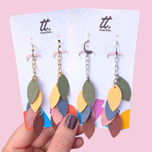 a hand holding a pair of earrings