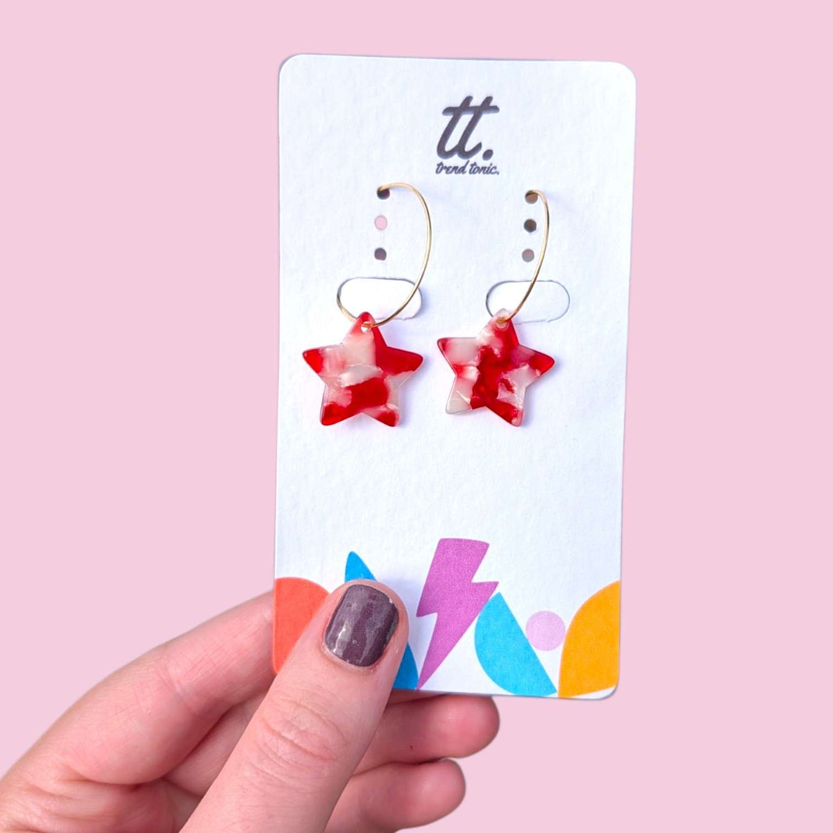 a hand holding a card with earrings
