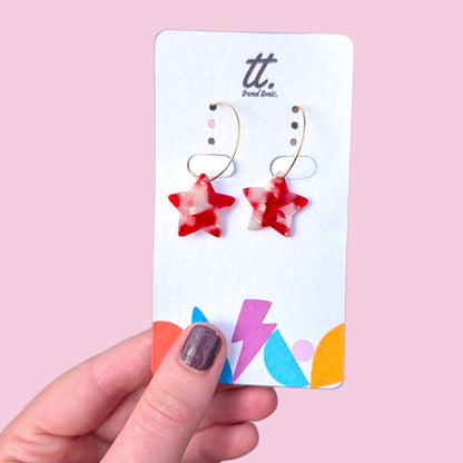 a hand holding a card with earrings