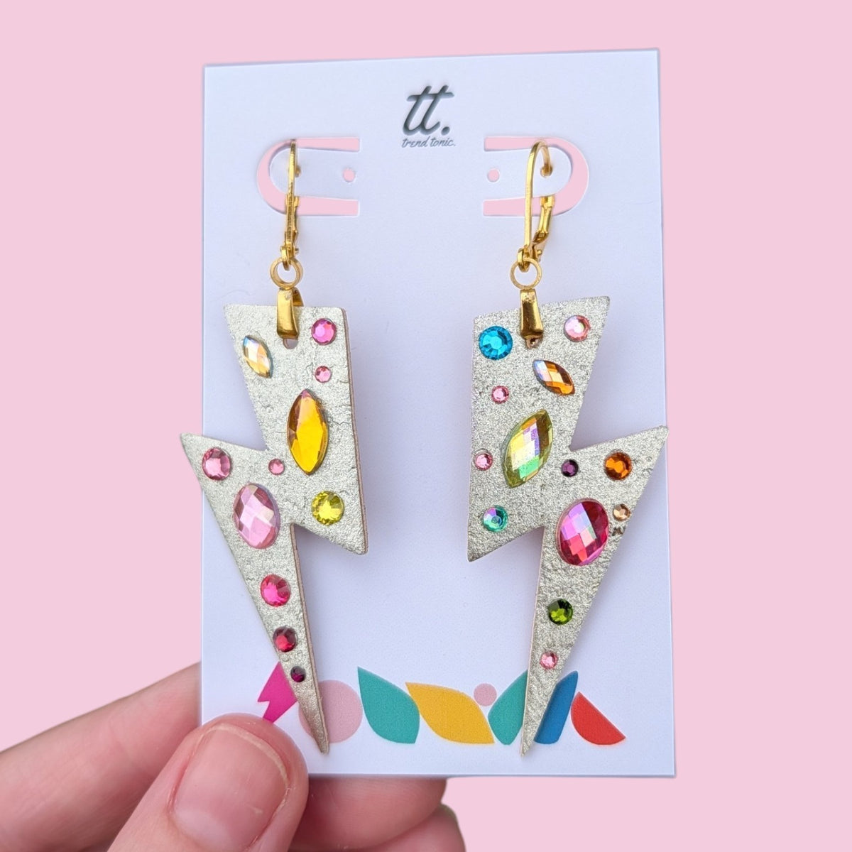 a hand holding a pair of earrings
