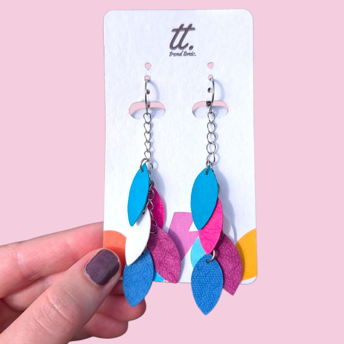a hand holding a pair of earrings