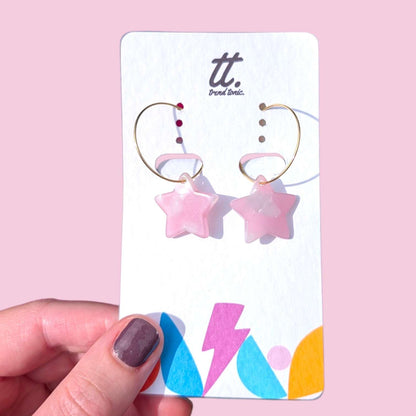a hand holding a pair of earrings