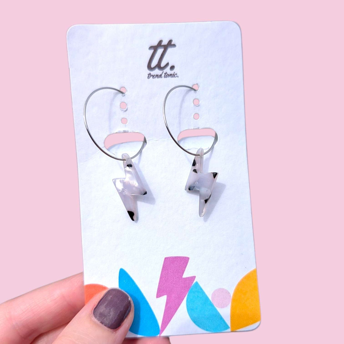 a hand holding a pair of earrings