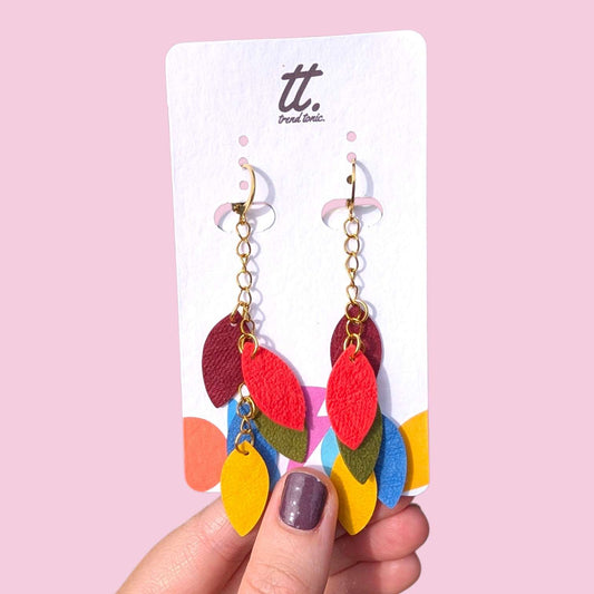 a hand holding a pair of earrings