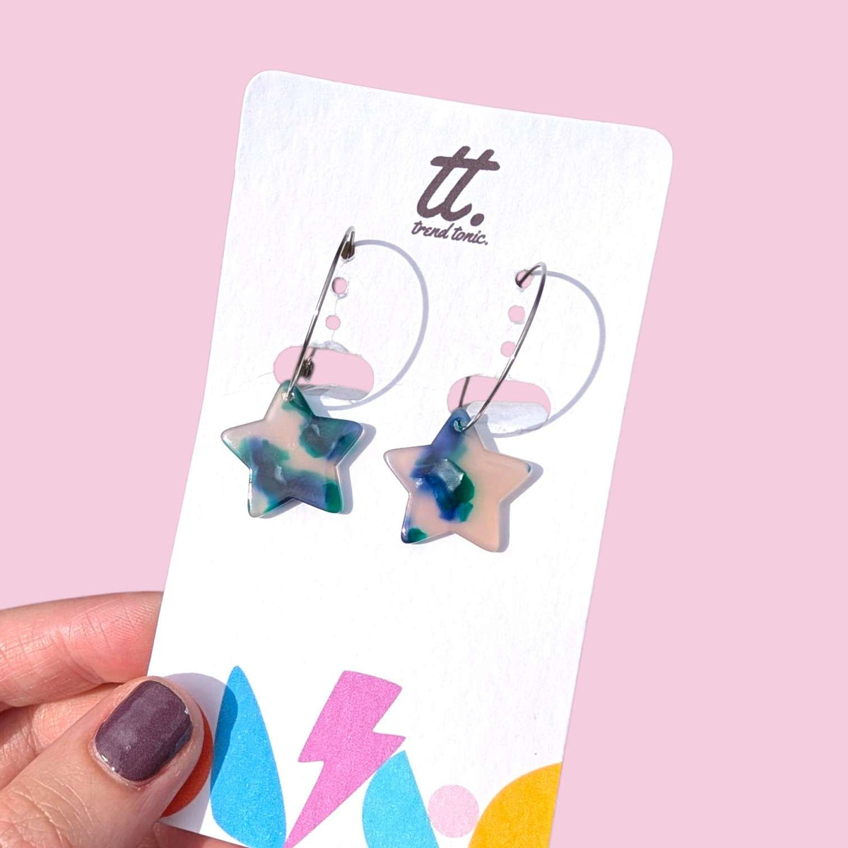 a hand holding a pair of earrings