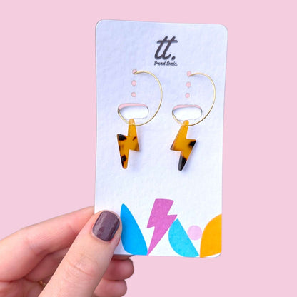 a hand holding a card with earrings