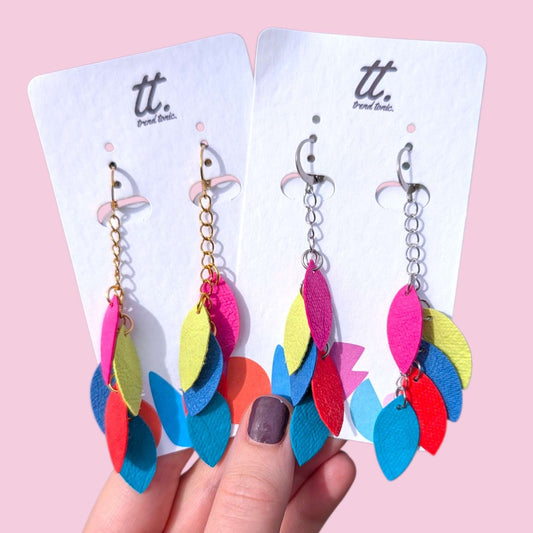 a hand holding a pair of earrings