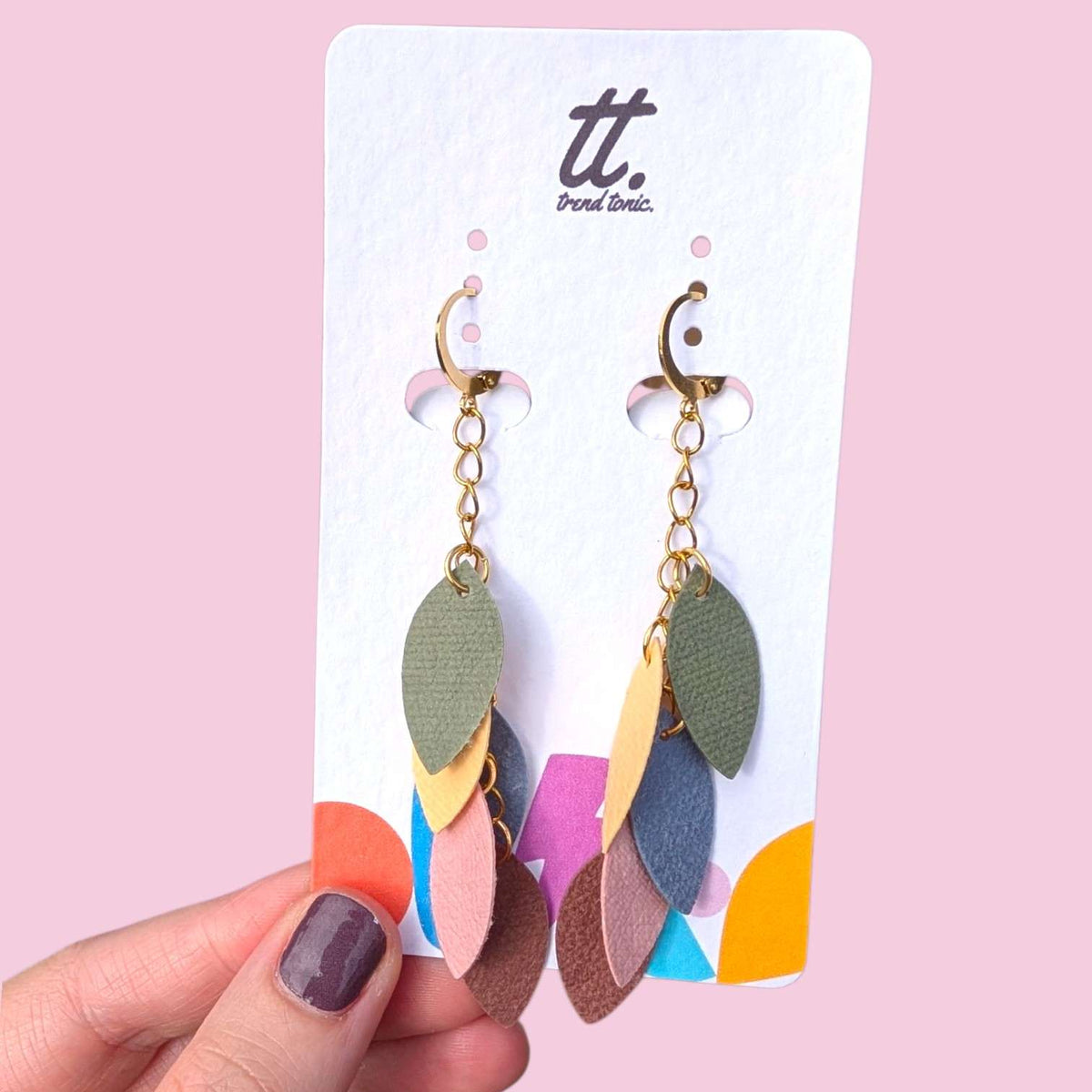 a hand holding a pair of earrings