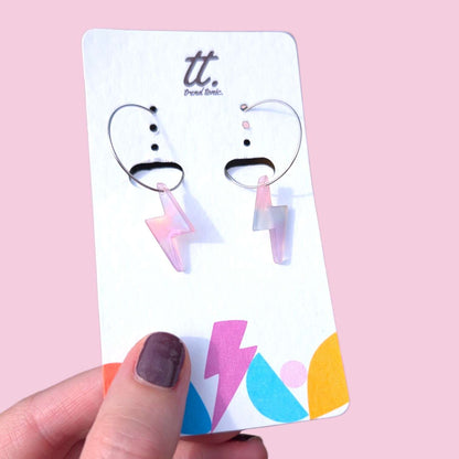 a hand holding a pair of earrings