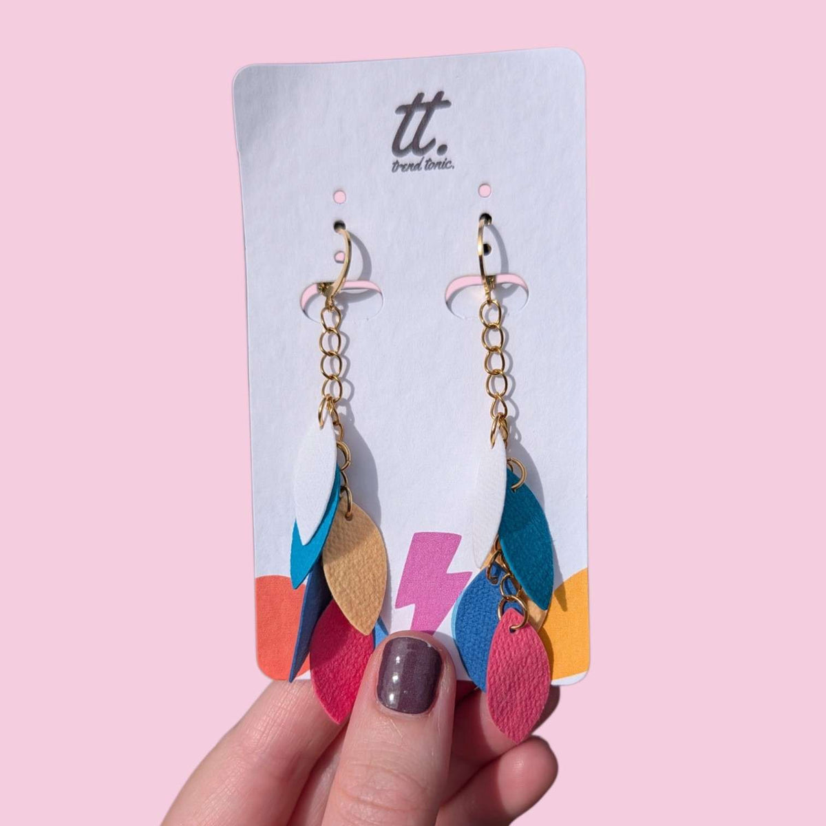 a hand holding a pair of earrings