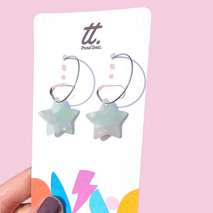 a hand holding a card with earrings