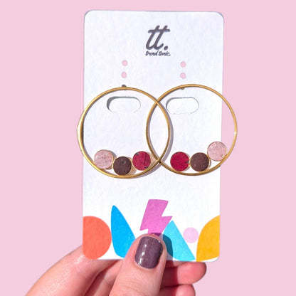 a hand holding a card with earrings