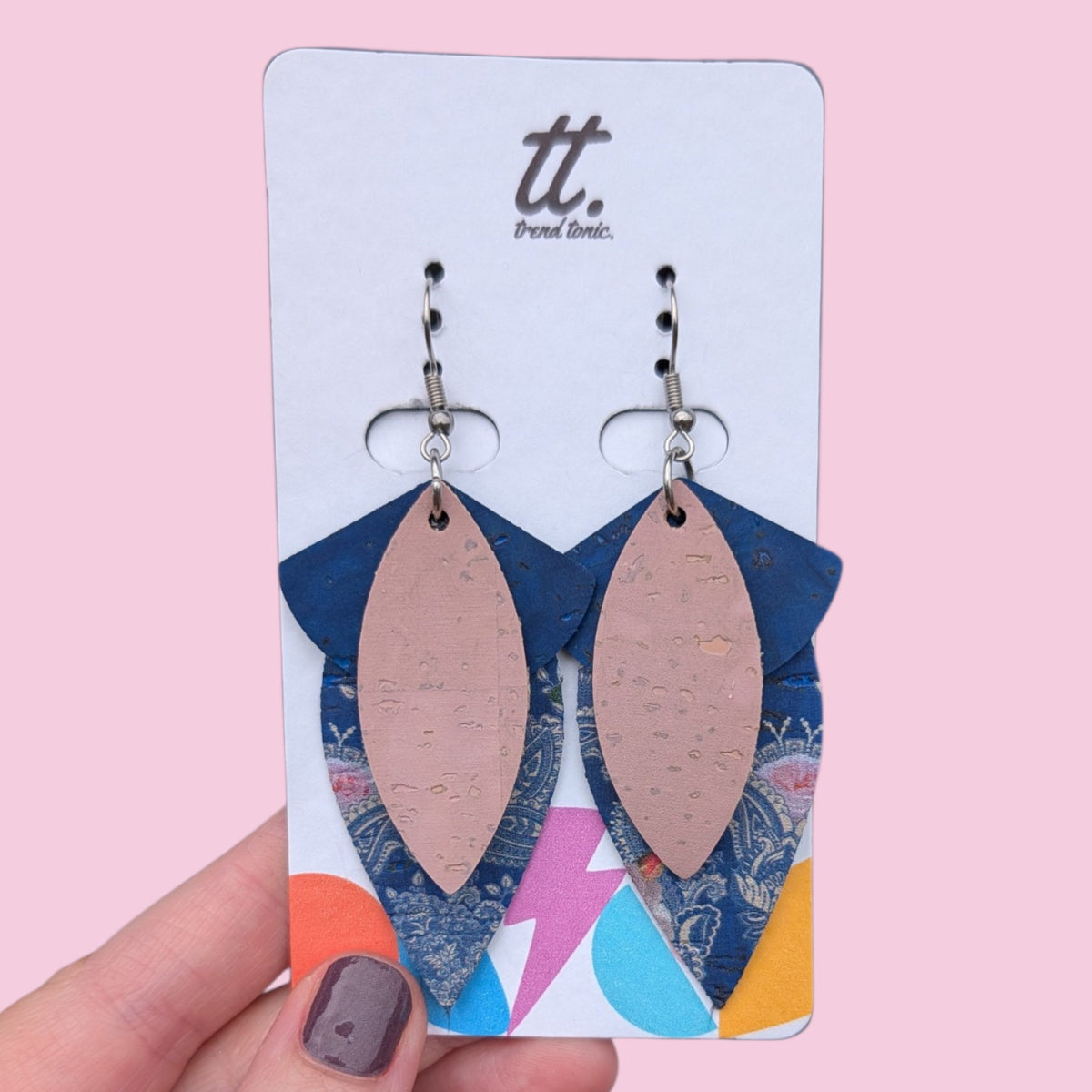 a hand holding a pair of earrings
