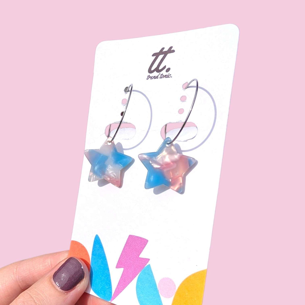 a hand holding a pair of earrings