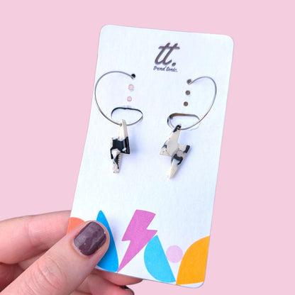 a hand holding a pair of earrings