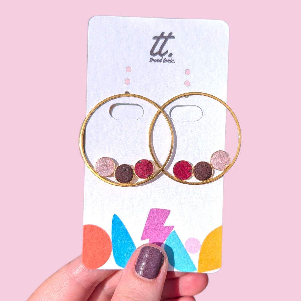 a hand holding a card with earrings